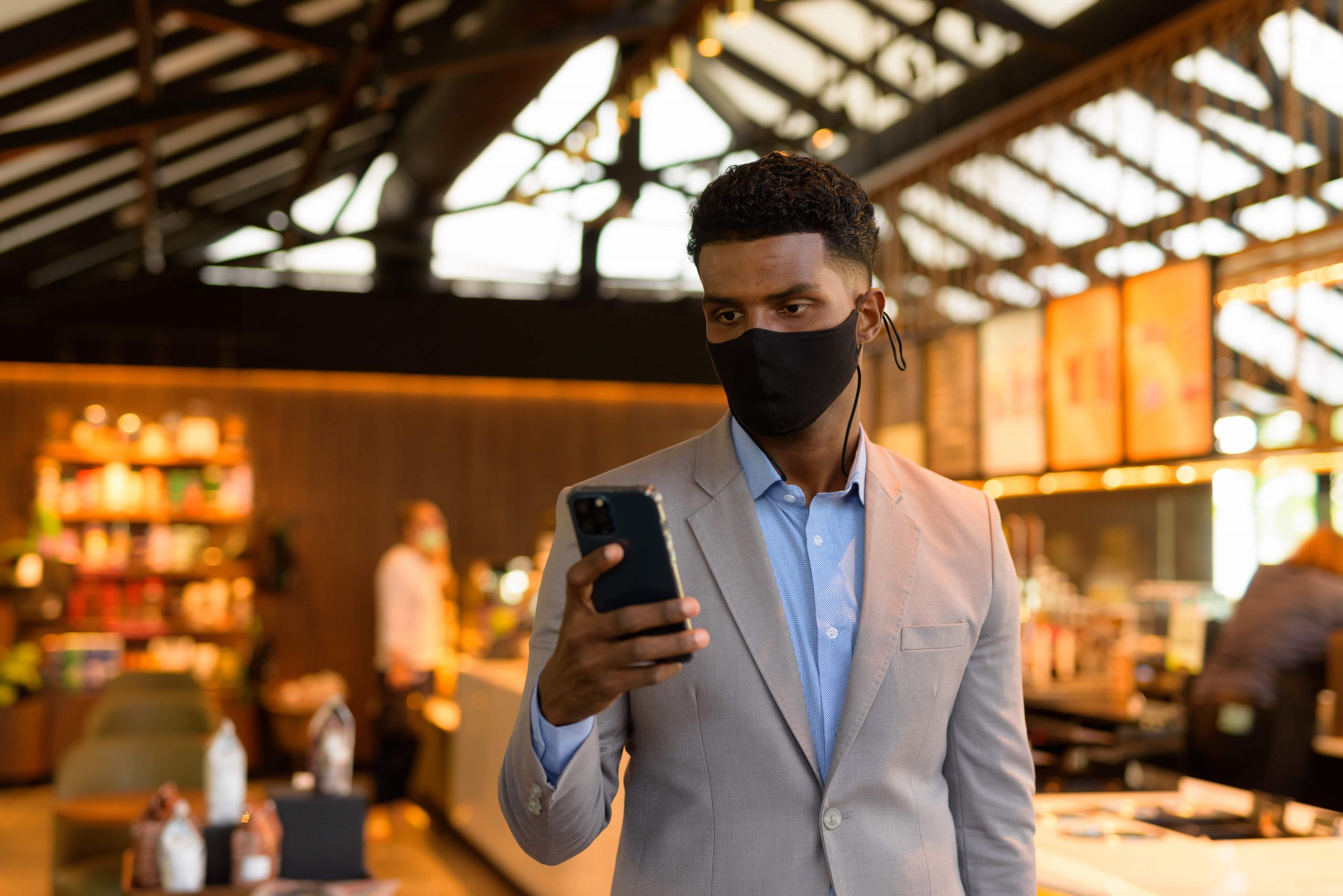 african-businessman-at-coffee-shop-wearing-face-ma-2021-09-03-00-42-44-utc-min (1)