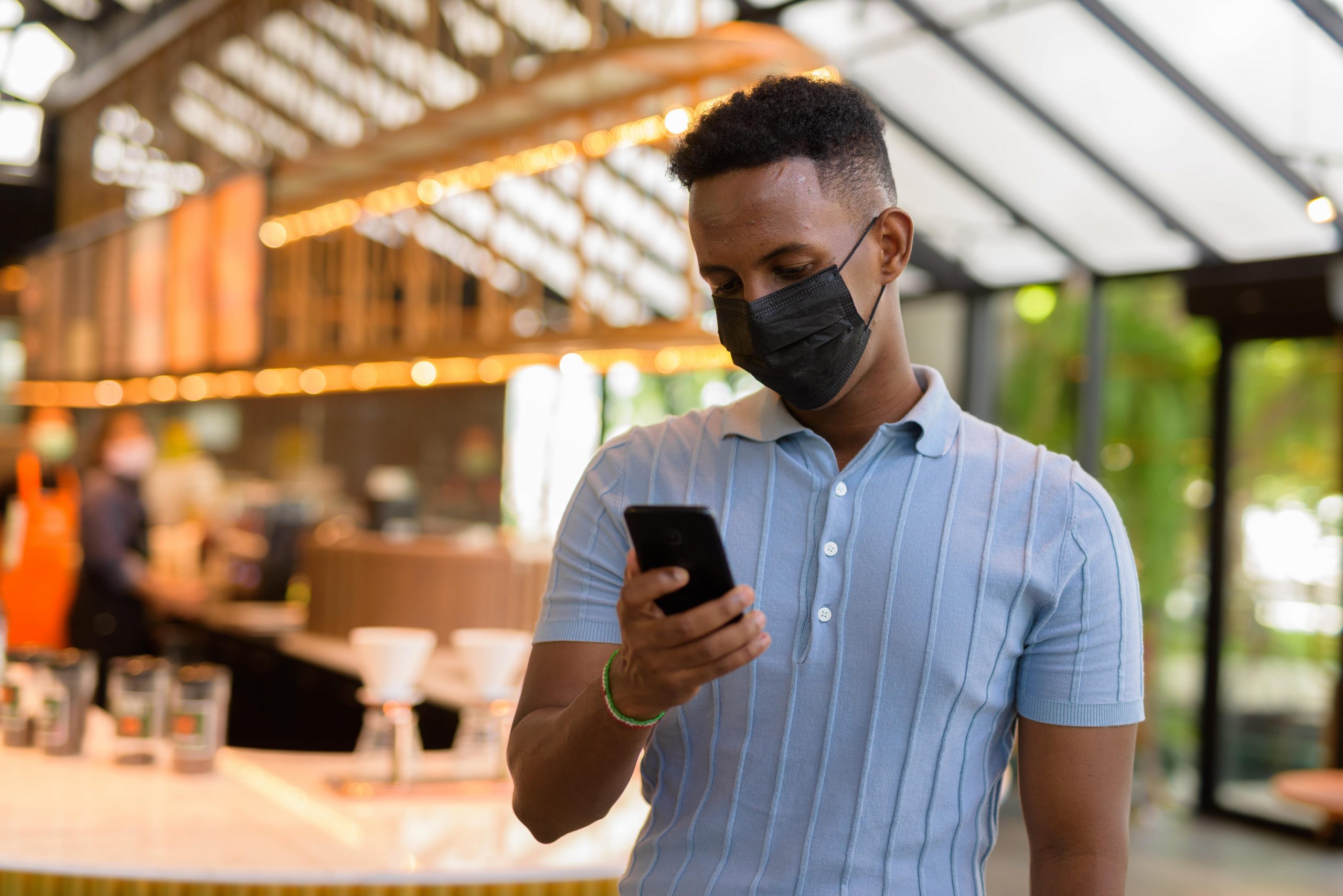 african-businessman-wearing-face-mask-in-coffee-sh-2021-09-03-02-49-20-utc-min