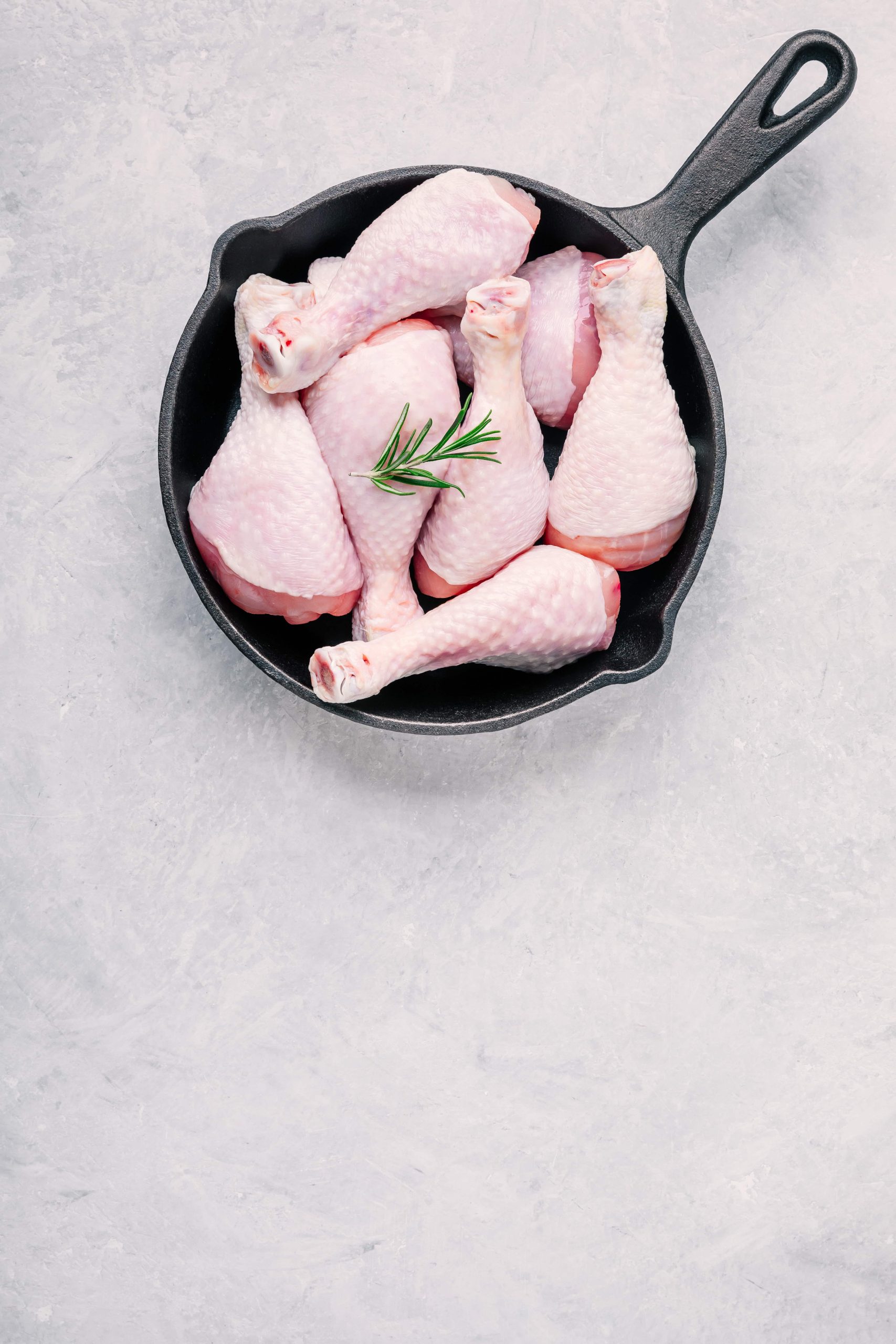 raw-uncooked-chicken-legs-with-rosemary-in-cast-i-2021-08-26-16-01-25-utc-min