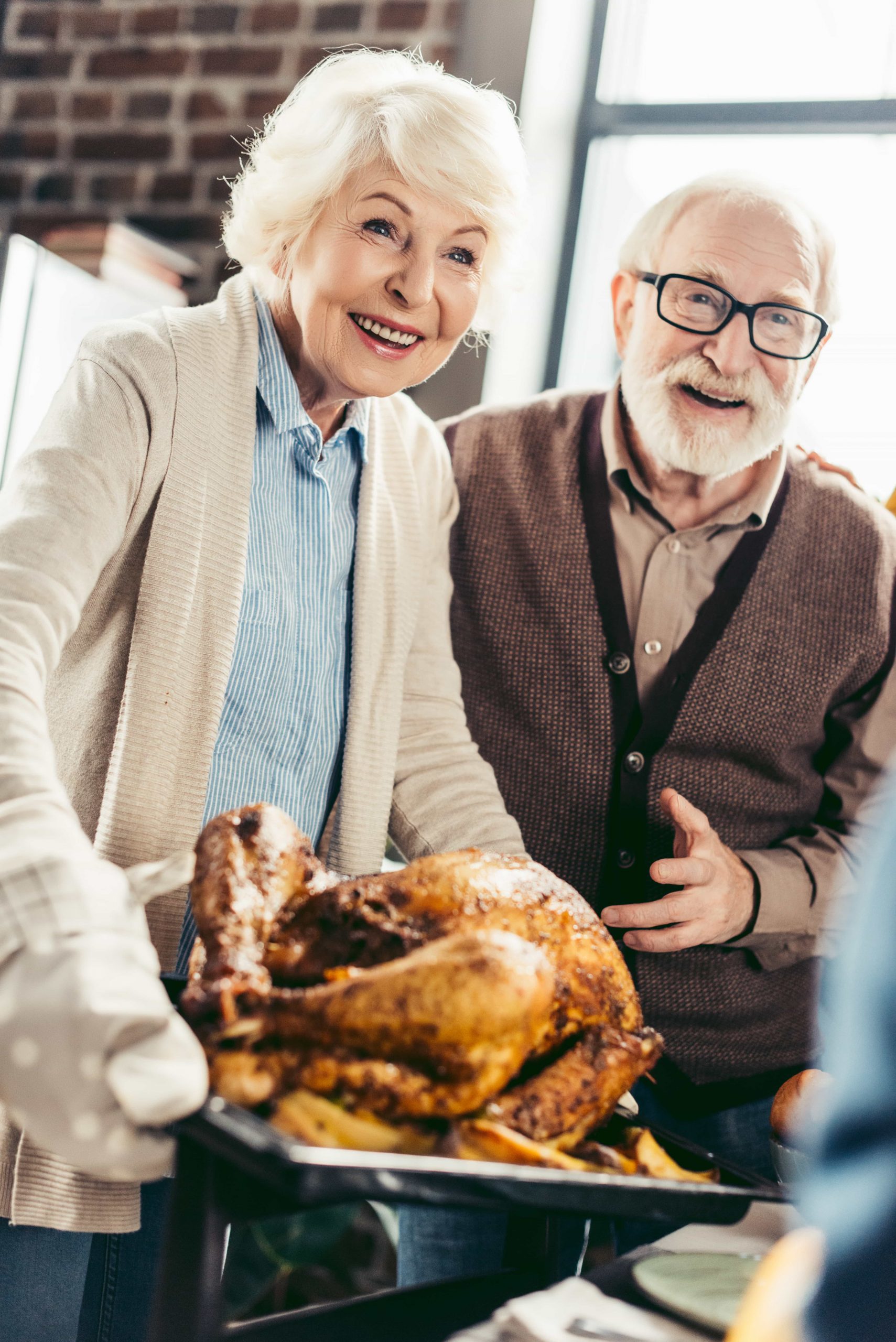 happy-senior-couple-with-thanksgiving-turkey-on-tr-2022-11-02-04-16-18-utc-min